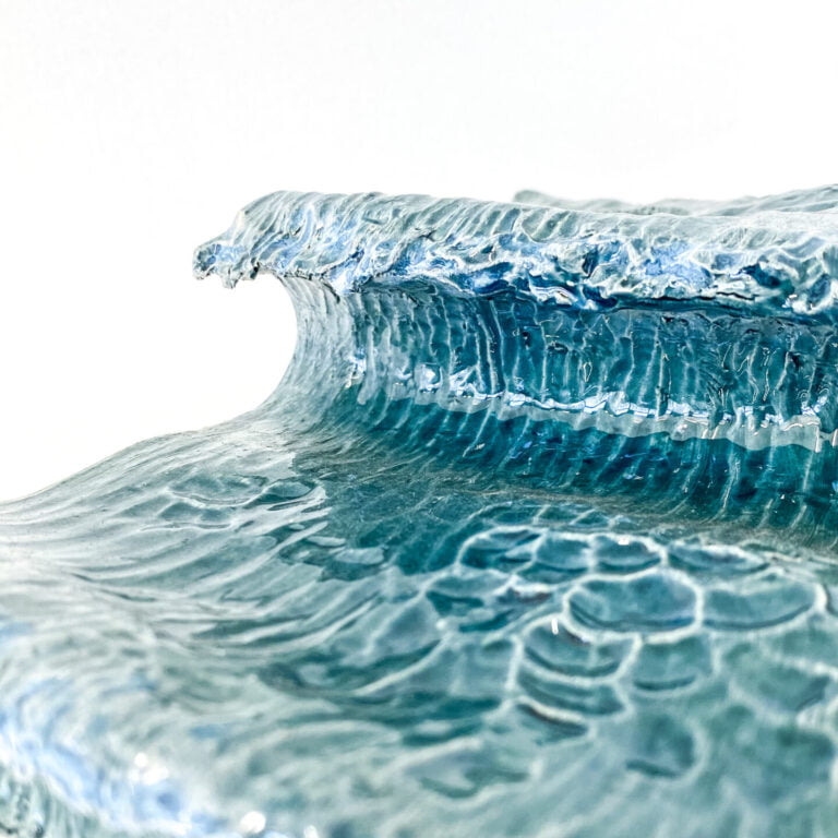 Wave in glazed ceramic. Sculpture created by Jaime Carvalho. Currently in the exhibition at Galeria Resistência in Lisbon. Inspired by the sea and wanting to represent its beauty and strength, Jaime developed a series of works in different materials, such as marble, wood, and metal, representing waves and the sea.