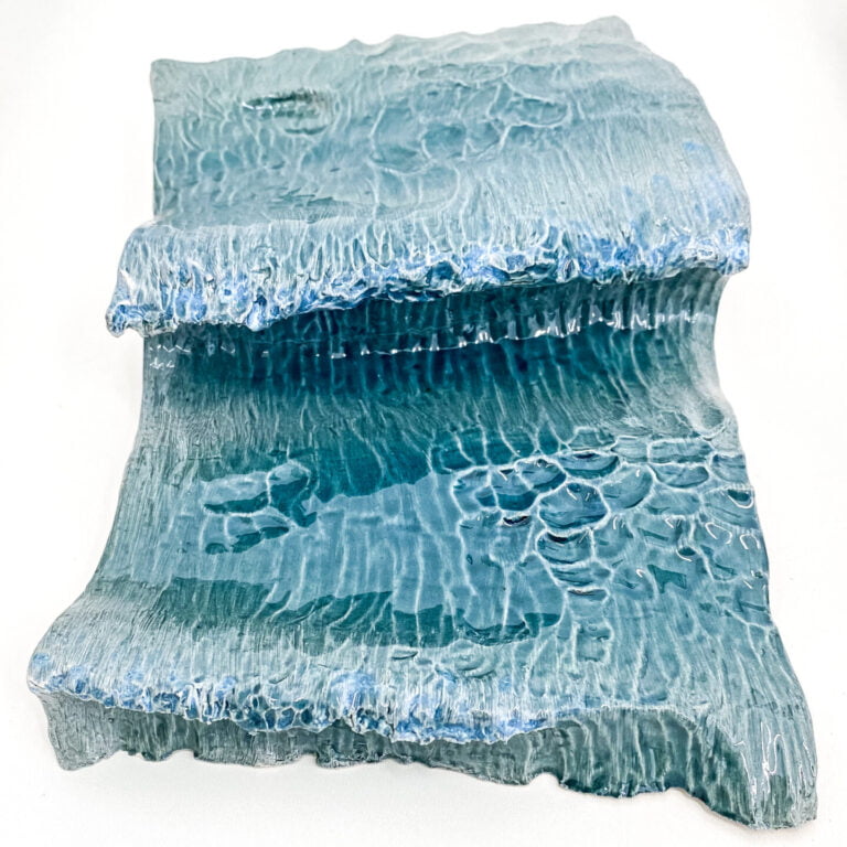 Wave in glazed ceramic. Sculpture created by Jaime Carvalho. Currently in the exhibition at Galeria Resistência in Lisbon. Inspired by the sea and wanting to represent its beauty and strength, Jaime developed a series of works in different materials, such as marble, wood, and metal, representing waves and the sea.